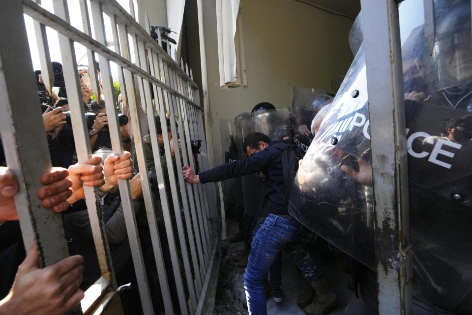 Anti-government protesters scuffle with riot police outside the ministry of Justice, in Beirut, Lebanon, Thursday, Jan. 26, 2023. Scores of protesters Thursday scuffled with riot police as they tried to break into the Beirut Justice Palace, rejecting an order from Lebanon's judiciary that further crippled the probe into a massive port explosion over two years ago. (AP Photo/Hassan Ammar)