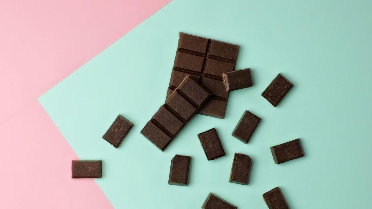 dark chocolate bar pieces on a pink and mint green color blocked background