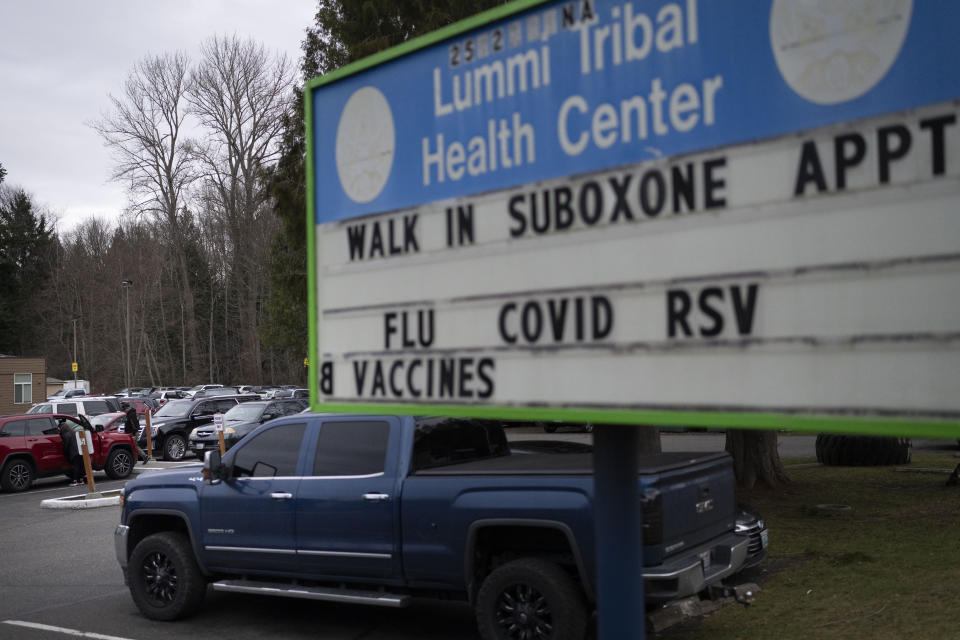 People walk through the parking lot of the Lummi Tribal Health Center advertising walk-in appointments for Suboxone, a medicine used to treat opioid dependence, on the Lummi Reservation, Thursday, Feb. 8, 2024, near Bellingham, Wash. The Lummi Nation declared a state of emergency due to the fentanyl crisis in 2023. Washington State tribal leaders are urging state lawmakers to pass a bill that would send at least $7.75 million in funding to tribal nations to help them stem a dramatic rise in opioid overdose deaths. (AP Photo/Lindsey Wasson)