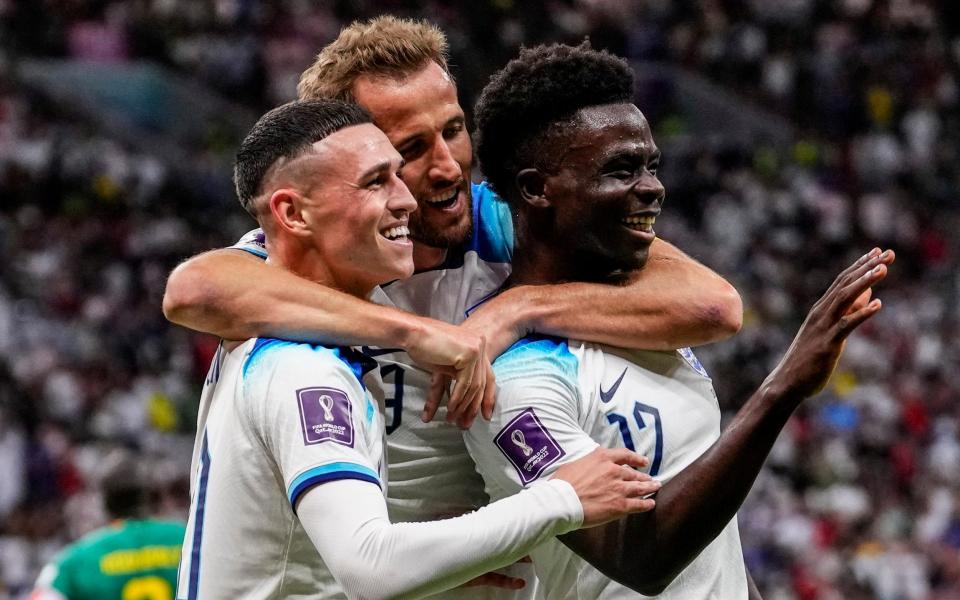 England's Bukayo Saka celebrates with Harry Kane and Phil Foden after scoring his side's third goal during the World Cup round of 16 match against Senegal in Qatar. Dated: Dec 4, 2022 - Manu Fernandez/AP