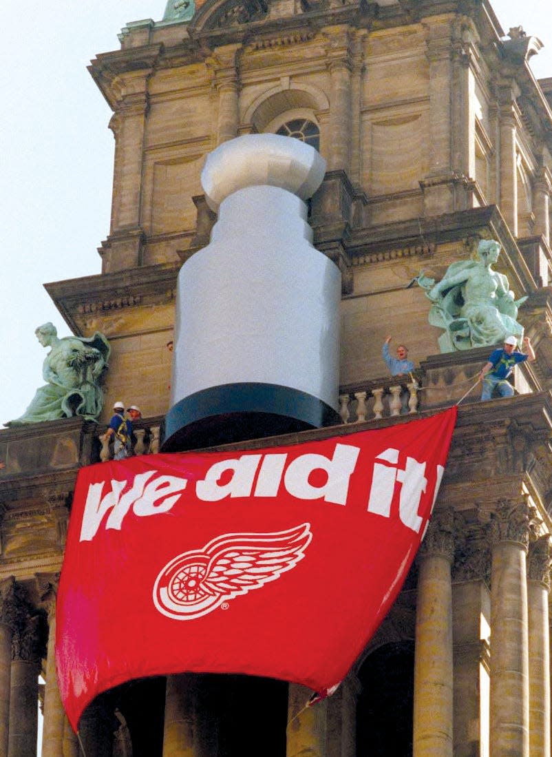 Lowered from a helicopter and secured by Barton Malow workers, a 25-foot Stanley Cup made its debut on the Wayne County Building the morning after Game 4.