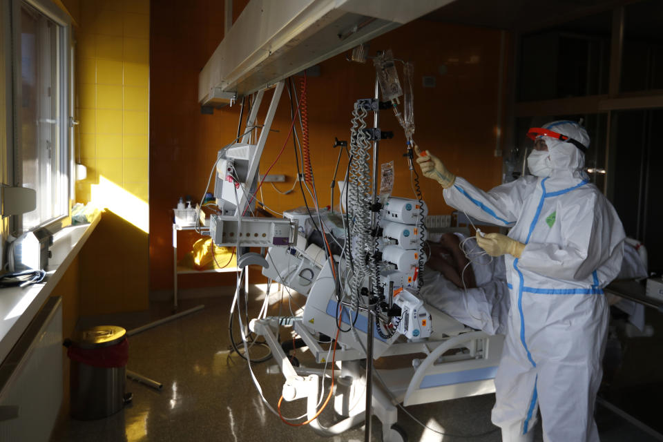 A healthcare worker attends to a COVID-19 patient in an intensive care unit (ICU) at Na Bulovce hospital in Prague, Czech Republic, Thursday, Oct. 1, 2020. A record surge of new coronavirus infections in the Czech Republic in September has been followed by a record surge of those hospitalized with COVID-19. The development has started to put the health system in the country under serious pressure for the first time since the pandemic hit Europe. (AP Photo/Petr David Josek)