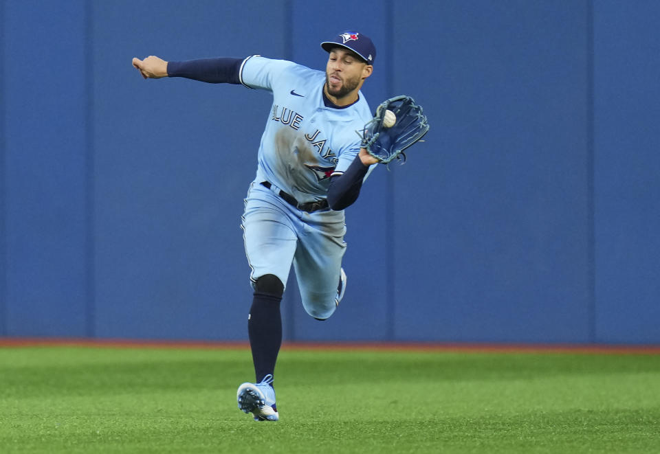 Toronto Blue Jays center fielder George Springer (4) makes a running catch to out Seattle Mariners center fielder Julio Rodriguez during the second inning of a baseball game in Toronto, Monday, May 16, 2022. (Nathan Denette/The Canadian Press via AP)