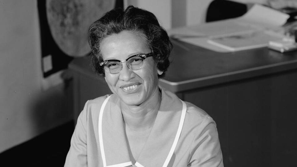 A black and white photo of Katherine Johnson sitting at her desk at NASA.