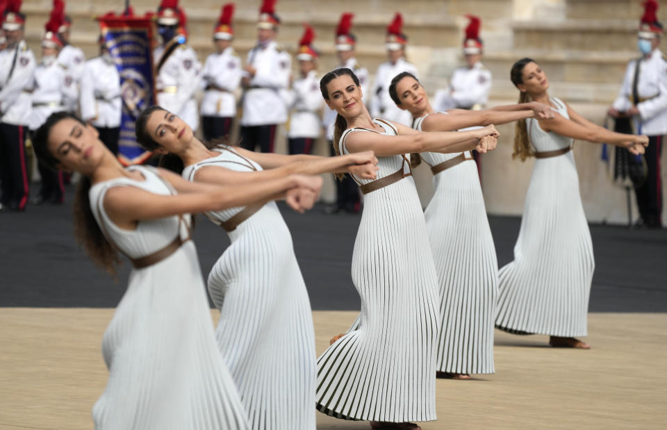 Performers dance during the Olympic flame handover ceremony at Panathinean stadium in Athens, Greece, Tuesday, Oct. 19, 2021. The flame will be transported by torch relay to Beijing, China, which will host the Feb. 4-20, 2022 Winter Olympics. (AP Photo/Thanassis Stavrakis)