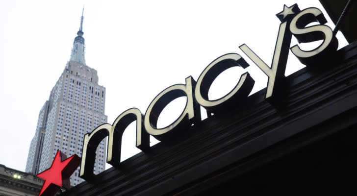 Macy's (M) logo on storefront in city with white sky behind