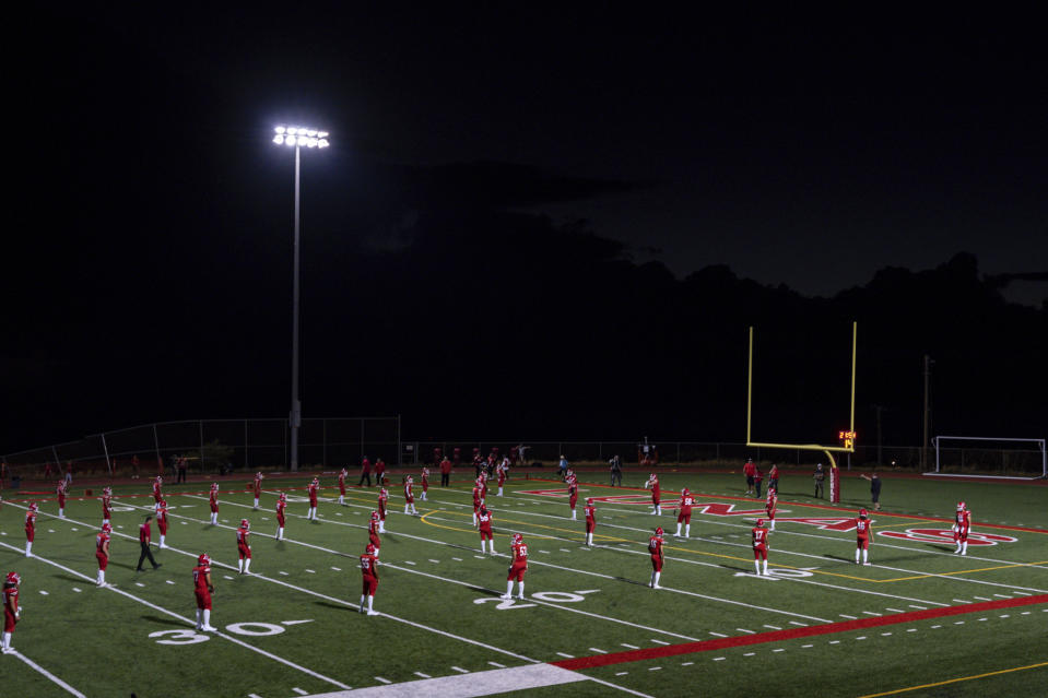 The Lahainaluna High School football team practices before their homecoming game at Sue D. Cooley Stadium, Saturday, Oct. 21, 2023, in Lahaina, Hawaii. Lahainaluna’s varsity and junior varsity football teams are getting back to normal since the devastating wildfire in August. (AP Photo/Mengshin Lin)