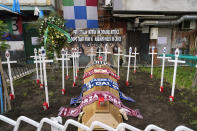 A mock cemetery with crosses bearing the Italian Serie A soccer teams flags and a coffin with the scarfs of the Juventus, Milan and Inter teams and a banner in background reading: " for all of Italy an atrocious pain, after so many years we have put you all on the crosses" , is seen in Naples, Italy, Sunday, April 30, 2023. After Napoli's game was moved to Sunday, the team could secure the title in front of their own fans by beating Salernitana — if Lazio fails to win at Inter Milan earlier in the day. Diego Maradona led Napoli to its only previous Serie A titles in 1987 and 1990. (AP Photo/Gregorio Borgia)