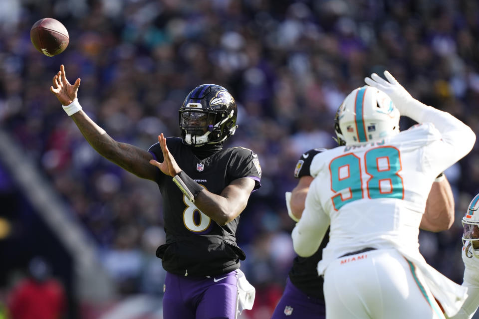 Baltimore Ravens quarterback Lamar Jackson (8) throws a pass under pressure from Miami Dolphins defensive tackle Raekwon Davis (98) during the first half of an NFL football game in Baltimore, Sunday, Dec. 31, 2023. (AP Photo/Matt Rourke)