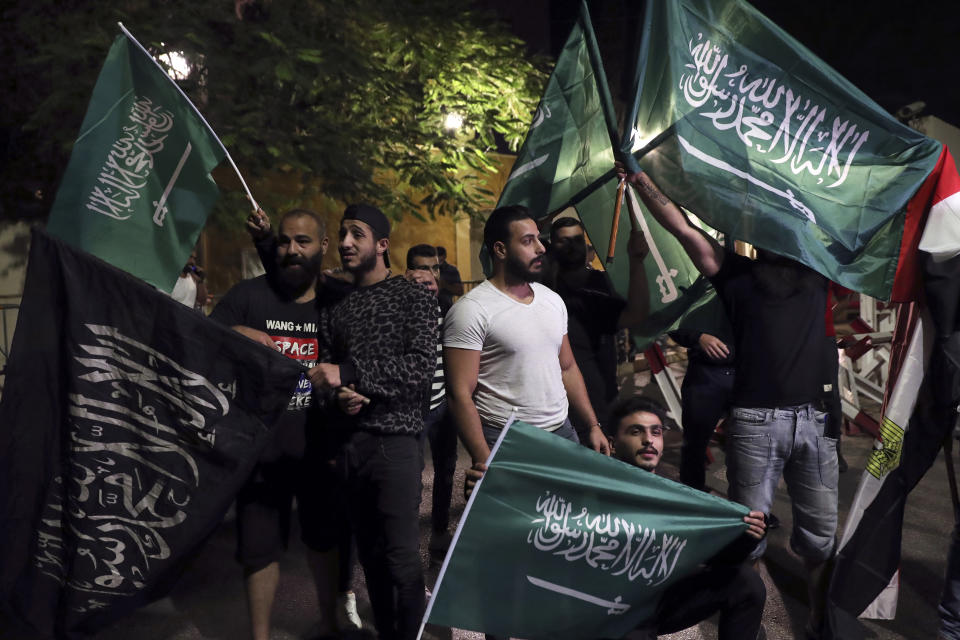 FILE - Lebanese hold Saudi Arabia flags during a protest in support of the kingdom against comments made by a Lebanese minister over the war in Yemen, in front of the Saudi Arabia Embassy in Beirut, Lebanon, Oct. 30, 2021. Televised comments by George Kordahi, a Lebanon Cabinet minister about the war in Yemen exposed the depth of the crisis with Saudi Arabia, once a strong ally that poured millions and offered unwavering political support in this small Mediterranean nation. The crisis over veered into diplomatic isolation of Lebanon and threatens to split a new coalition government tasked with halting the country’s economic meltdown. (AP Photo/Bilal Hussein, File)