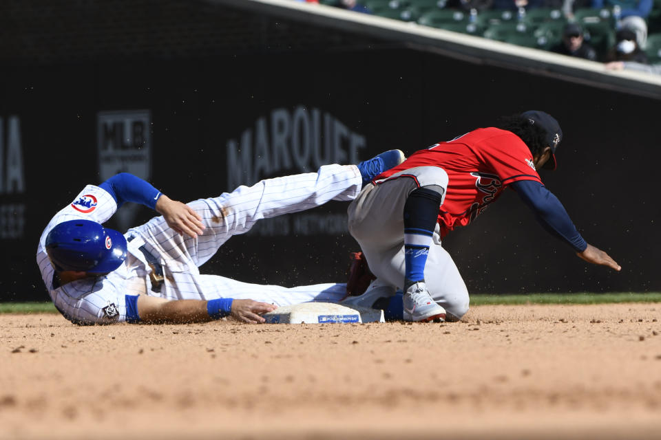 Chicago Cubs second baseman David Bote, left, is tagged out by Atlanta Braves second baseman Ozzie Albiies during the sixth inning of a baseball game Friday, April 16, 2021, in Chicago. (AP Photo/Matt Marton)