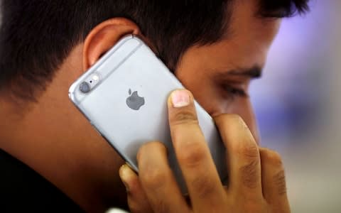 A man holds an iPhone - Credit: Reuters