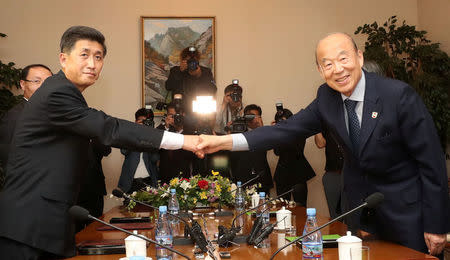 South Korea's delegation leader Park Kyung-seo, head of the Korean Red Cross, and North Korea's delegation leader Pak Yong-il, vice chairman of the Committee for the Peaceful Reunification of the Country, shake hands during their meeting at a hotel on Mount Kumgang, North Korea, June 22, 2018. Yonhap via REUTERS