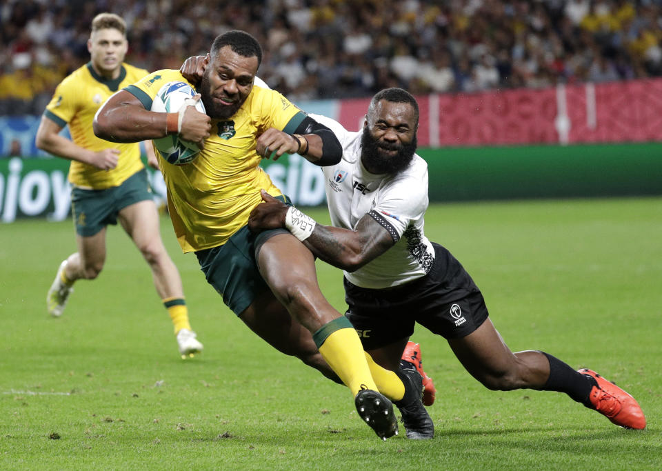 Australia's Samu Kerevi avoids the tackle of Fiji's Semi Radradra to score a try during the Rugby World Cup Pool D game at Sapporo Dome between Australia and Fiji in Sapporo, Japan, Saturday, Sept. 21, 2019. (AP Photo/Aaron Favila)