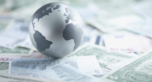 Metal globe resting on paper currency