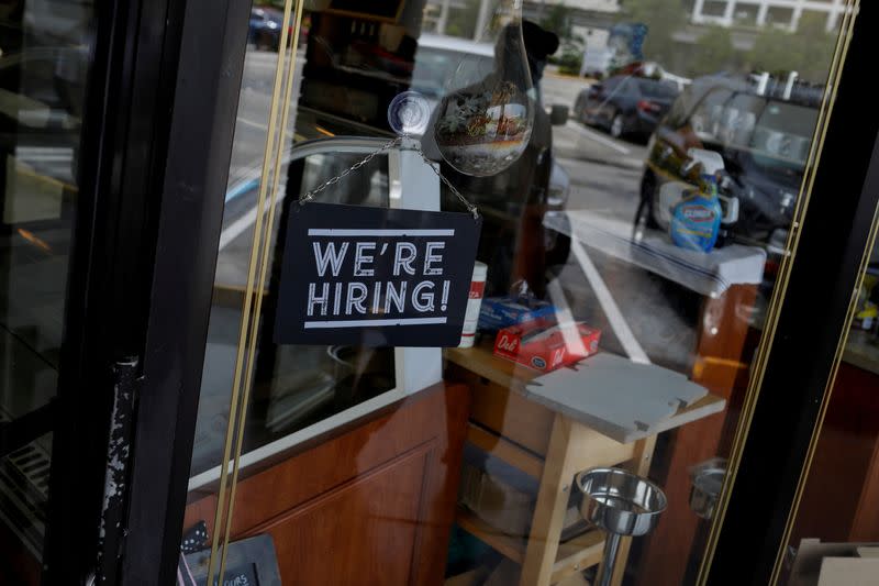 FILE PHOTO: A "We're Hiring" sign advertising jobs is seen at the entrance of a restaurant in Miami