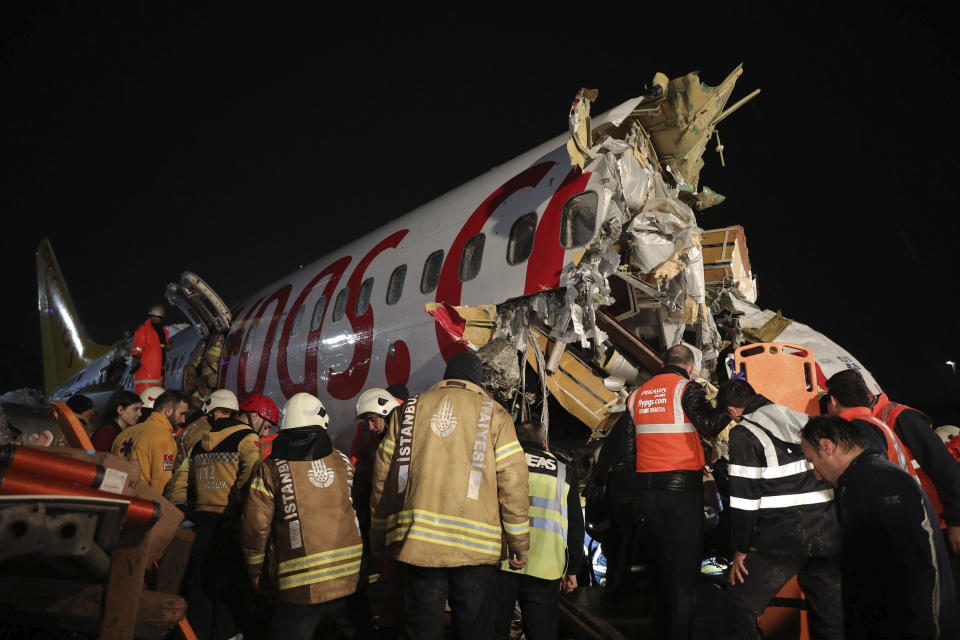 Rescue members and firefighters in front of the Pegasus Airlines plane that can be seen with its cockpit snapped off. Source: Can Erok/DHA via AP