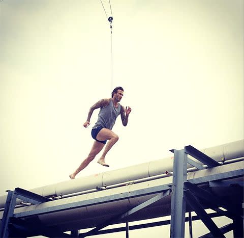 David Beckham takes a running leap across a rooftop. Photo: H&M Instagram.