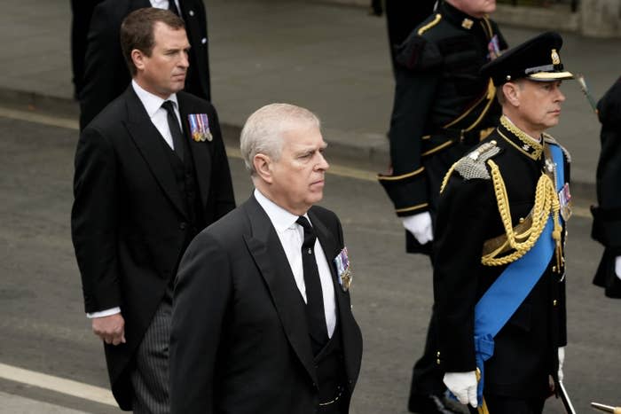 Peter Phillips and Prince Andrew wear suits alongside Prince Edward in military dress during the procession