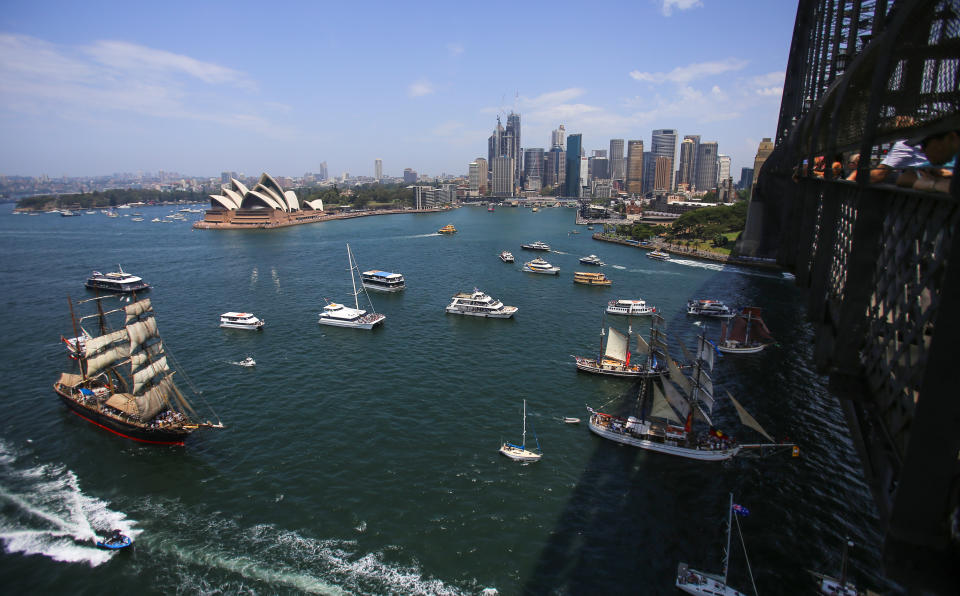 People watch as historic tall ships race from Bradleys Head towards the Sydney Harbour Bridge during Australia Day celebrations in Sydney.