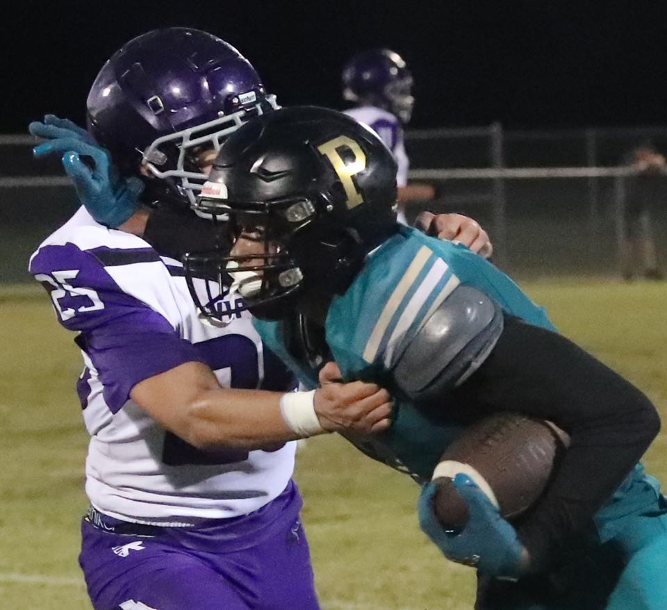 Pine Ridge High's Jayden Campbell #7 tries to fight off the tackle of Space Coast's Alex Banachoski #25, Friday September 8, 2023.