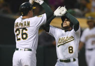 Oakland Athletics' Jed Lowrie, right, celebrates with Matt Chapman (26) after hitting a two-run home run off Seattle Mariners' Felix Hernandez in the third inning of a baseball game Tuesday, Aug. 14, 2018, in Oakland, Calif. (AP Photo/Ben Margot)