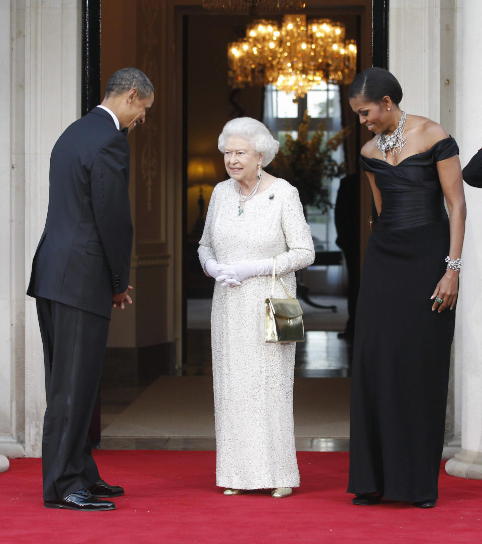FILE - U.S. President Barack Obama and first lady Michelle Obama welcome Queen Elizabeth II for a reciprocal dinner at Winfield House in London, May 25, 2011. Queen Elizabeth II, Britain's longest-reigning monarch and a rock of stability across much of a turbulent century, died Thursday, Sept. 8, 2022, after 70 years on the throne. She was 96. (AP Photo/Charles Dharapak, File)