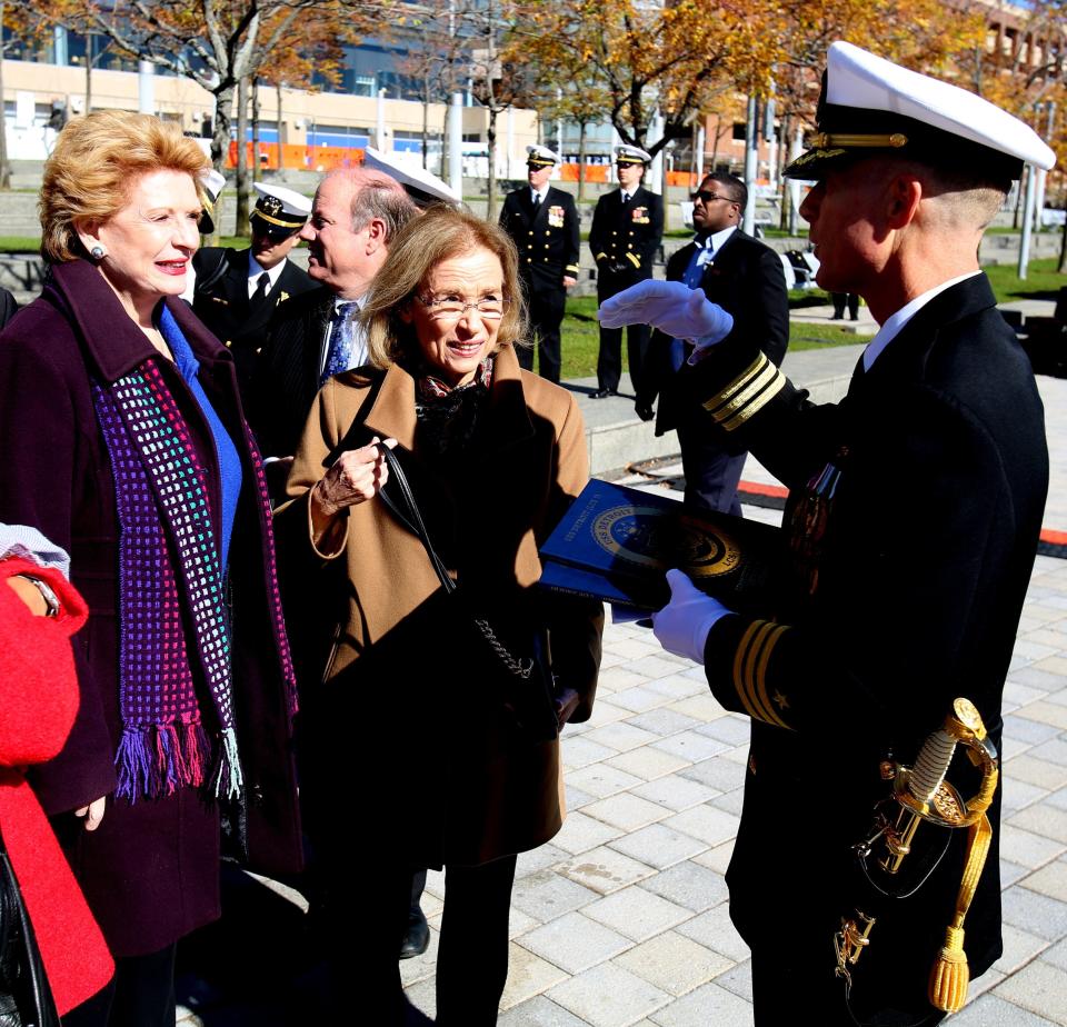 Senator Debbie Stabenow and Barbara Levin, the sponsor of the USS Detroit and wife of retired Senator Carl Levin, listen to Commanding Officer of the USS Detroit, Michael Desmond talk at the end of the commissioning ceremonies of the ship.