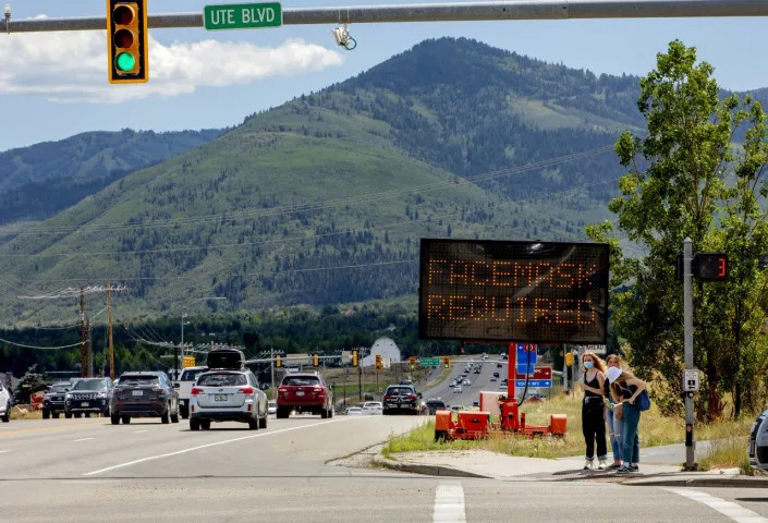 Pedestrians walk in front of a street sign that reads "Face Mask Requried" in Summit County near Park City, Utah, U.S., on Saturday, Aug. 1, 2020. Photographer: Kim Raff/Bloomberg via Getty Images <span class="copyright">Kim Raff/Bloomberg via Getty Images</span>