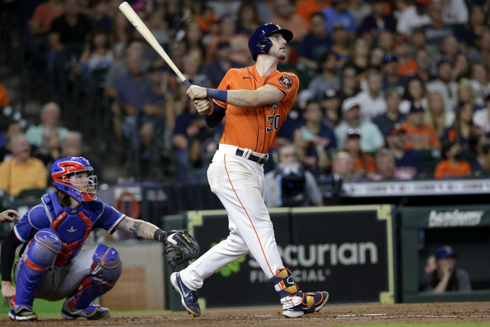 Houston Astros' Kyle Tucker, right, watches his three-run home run hit in front of Texas Rangers catcher Jonah Heim, left, during the third inning of a baseball game Friday, July 23, 2021, in Houston. (AP Photo/Michael Wyke)