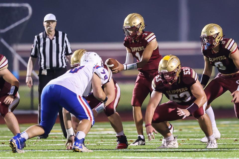 Portsmouth quarterback Aidan Thomas takes the snap from center Colton Brisard during the first half of Friday's Division I football game against Winnacunnet.