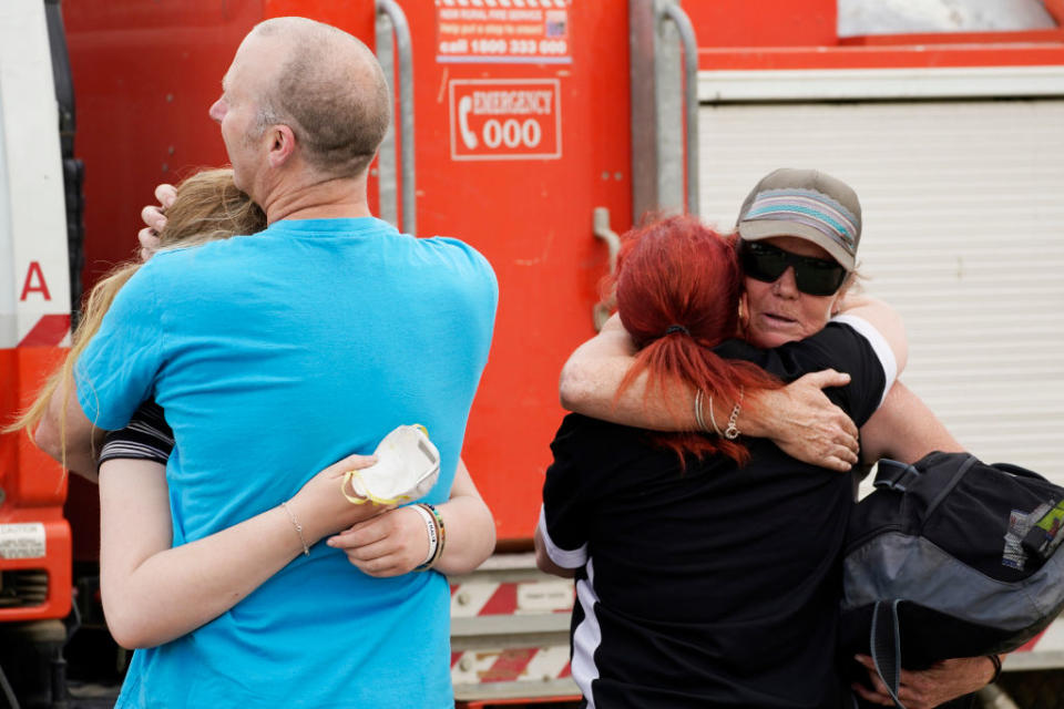 People embrace at Numeralla Rural Fire Brigade near the scene of a water tanker plane crash.