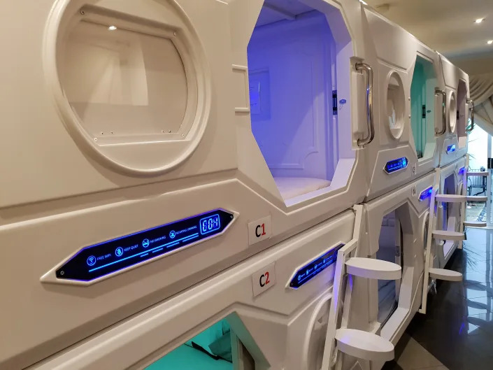 White sleeping pods with multi-colored lights inside