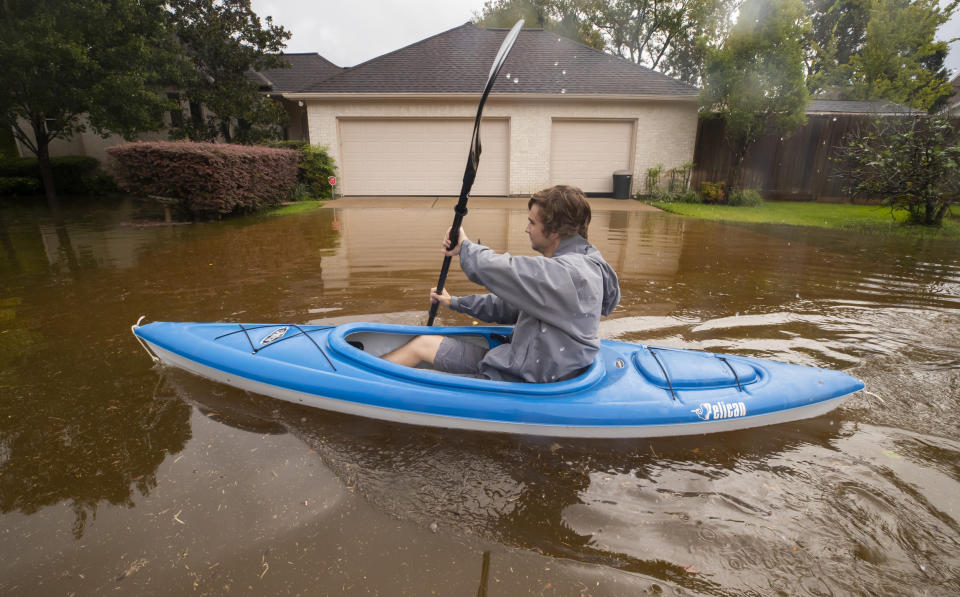 Kyle Harner kayaks along a flooded street in Friendswood, Texas, on Sept. 22, 2020.  (Stuart Villanueva / The Galveston County Daily News via AP file)