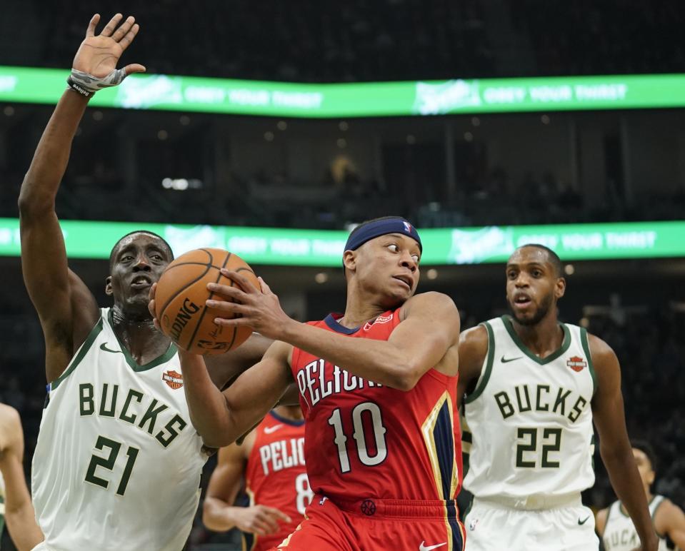 New Orleans Pelicans' Tim Frazier drives past Milwaukee Bucks' Khris Middleton (22) and Tony Snell (21) during the first half of an NBA basketball game Wednesday, Dec. 19, 2018, in Milwaukee. (AP Photo/Morry Gash)