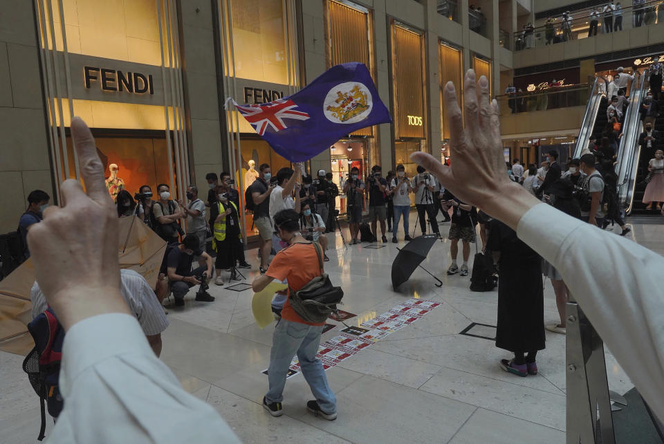 Protesters wave a Hong Kong colonial flag in a shopping mall during a protest against China's national security legislation for the city, in Hong Kong, Monday, June 1, 2020. The mouthpiece of China's ruling Communist Party says U.S. moves to end some trading privileges extended to Hong Kong grossly interfere in China's internal affairs and are doomed to fail. (AP Photo/Vincent Yu)