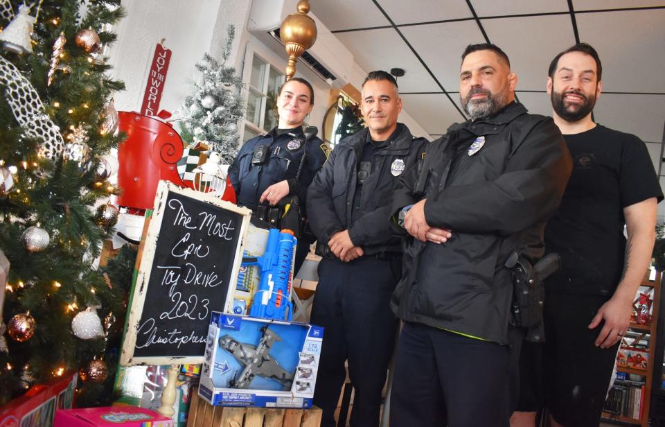 Fall River police officers Rachel Silvia, Eric Cabral and Freddy Mello, alongside Nathan Silvia, co-owner of Christopher's, pose with with toys collected for the Community Christmas Toy Drive on Friday, Nov. 17, 2023.