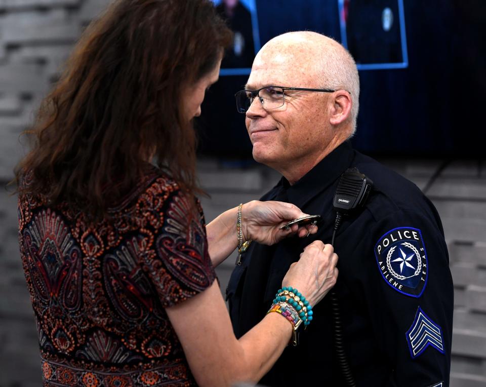 Terrill Perkins smiles as his wife Lisa pins on his new sergeant's badge during Wednesday's ceremony at the Abilene Police Department.