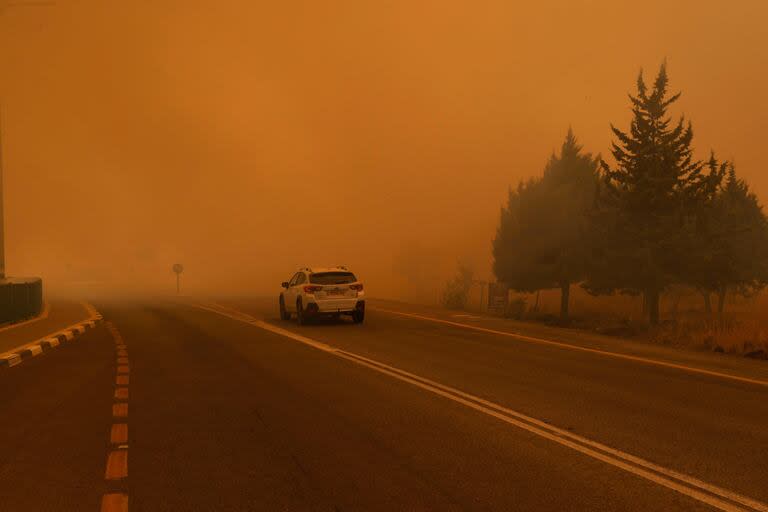 Un vehículo conduce en un área envuelta por el humo de los incendios después de que cohetes lanzados desde el sur del Líbano impactaran áreas en los Altos del Golán anexados por Israel, el 4 de julio de 2024.