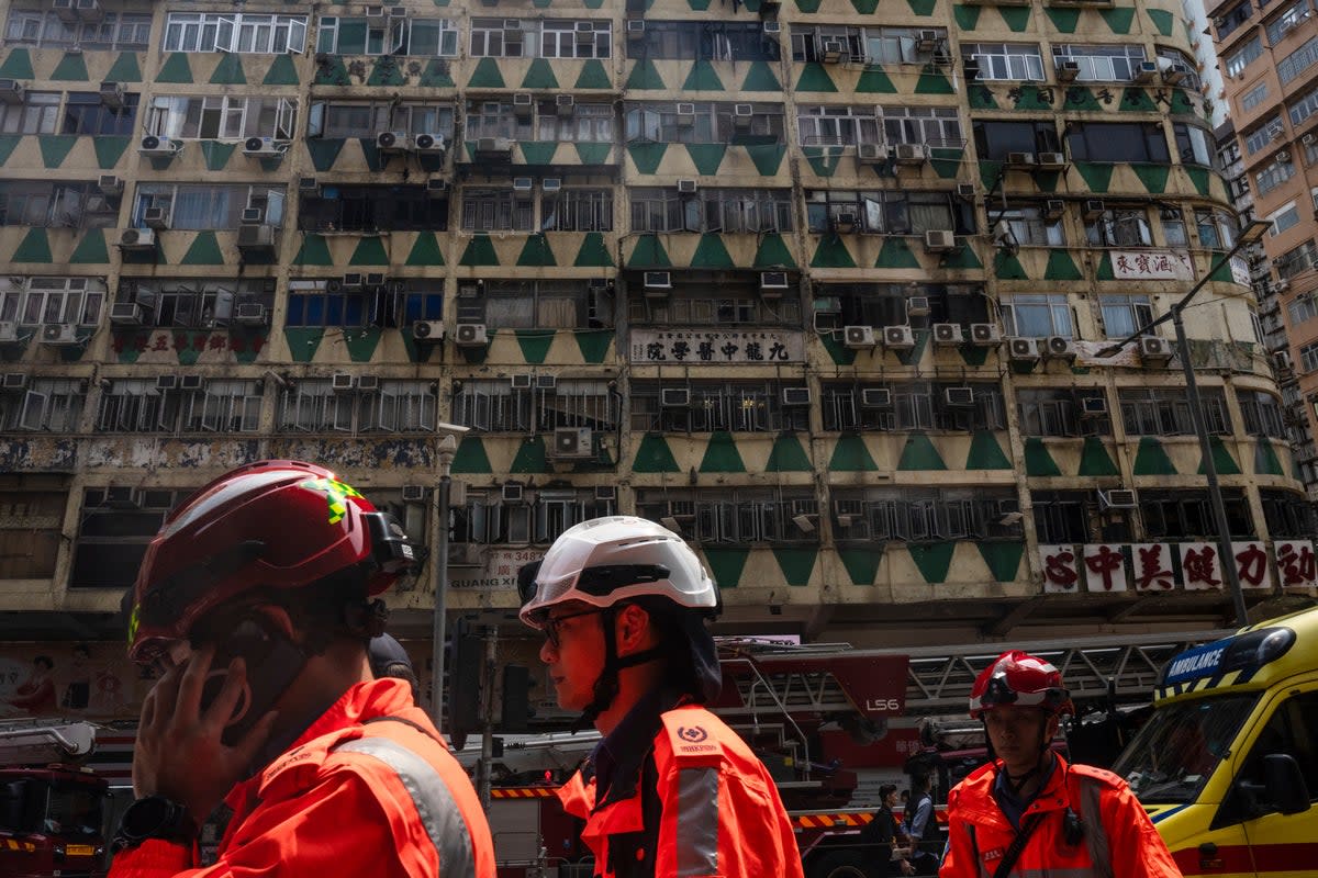 Firefighters walk past a building called New Lucky House where a fire started in Hong Kong, Wednesday, 10 April 2024 (AP)