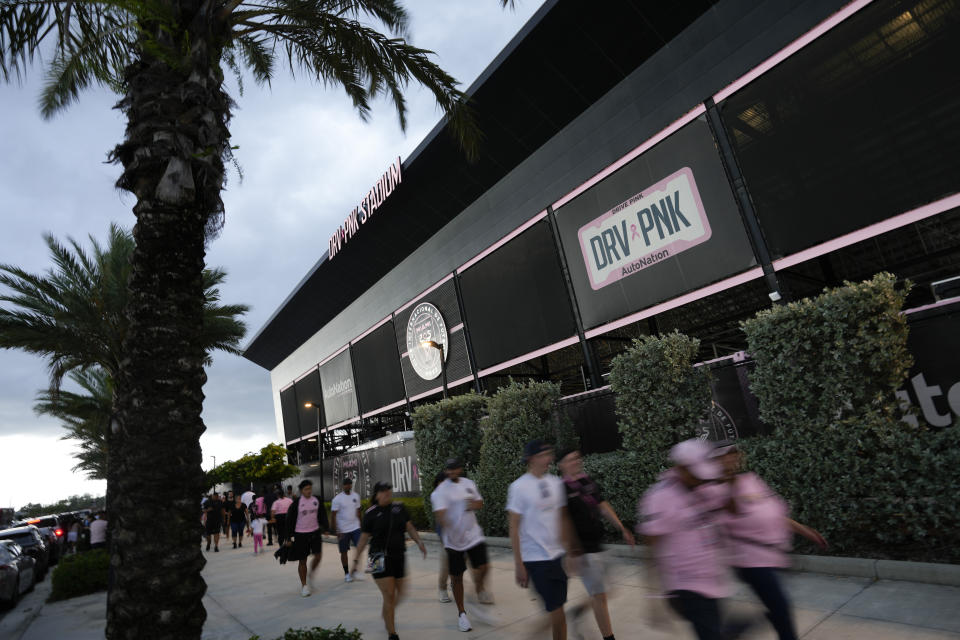 Fans walk outside DRV Pink Stadium, home of the Inter Miami MLS soccer team, for an event to present international superstar Lionel Messi one day after the team finalized his signing through the 2025 season, Sunday, July 16, 2023, in Fort Lauderdale, Fla. (AP Photo/Rebecca Blackwell)