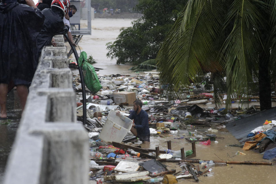 A resident tries to save belongings as floods continue to rise in Marikina, Philippines due to Typhoon Vamco on Thursday, Nov. 12, 2020. A typhoon swelled rivers and flooded low-lying areas as it passed over the storm-battered northeast Philippines, where rescuers were deployed early Thursday to help people flee the rising waters.(AP Photo/Aaron Favila)