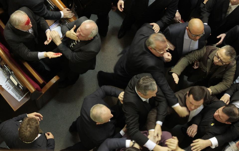 Ukrainian lawmakers scuffle as pro-government lawmaker Vladimir Malyshev, left, injured in the scuffle, has blood on his face in the Ukrainian parliament in Kiev, Ukraine, Thursday, Jan. 16, 2014. Lawmakers scuffled in the Ukrainian parliament during a debate on this year's budget. Despite the opposition's efforts to disrupt the vote, the budget draft, which has already been delayed by almost two months, was passed in its second reading. (AP Photo/Sergei Chuzavkov)