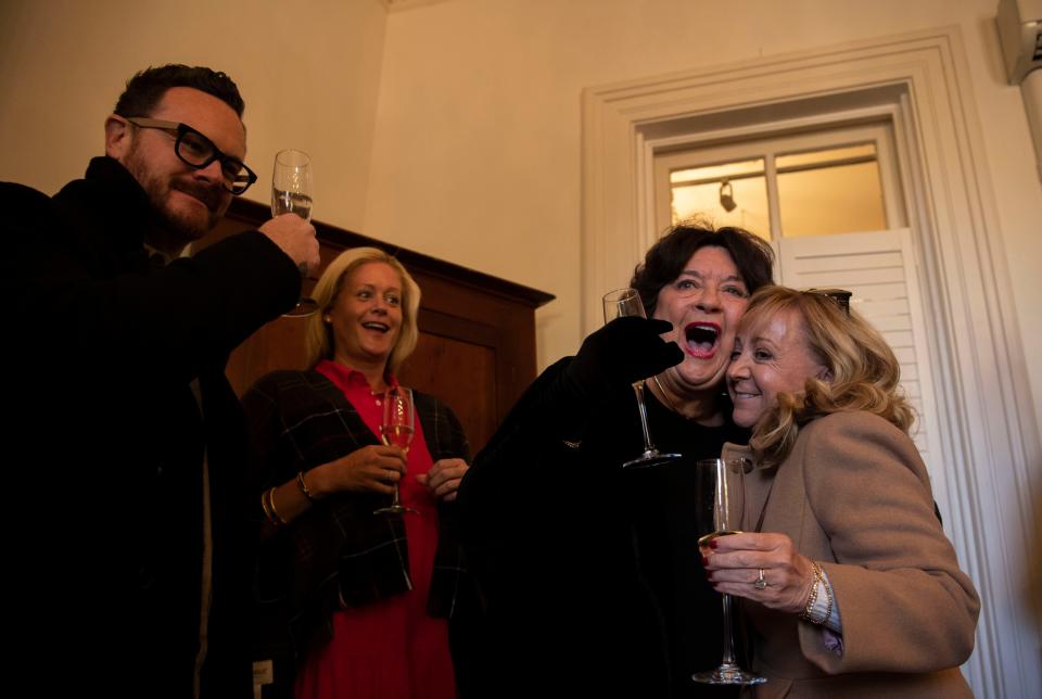 John Bond and Ellen Smith raise a toast of champagne while Sandra Morris and Jennifer Parker hug as they celebrate  groundbreaking at Franklin Grove Estate & Gardens in Franklin on Nov. 1.