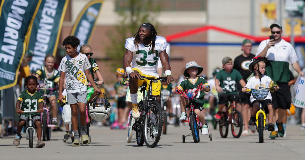 Green Bay Packers running back Aaron Jones rides with a group of kids along the DreamDrive before the start of training camp on Aug. 3, 2023, in Green Bay.