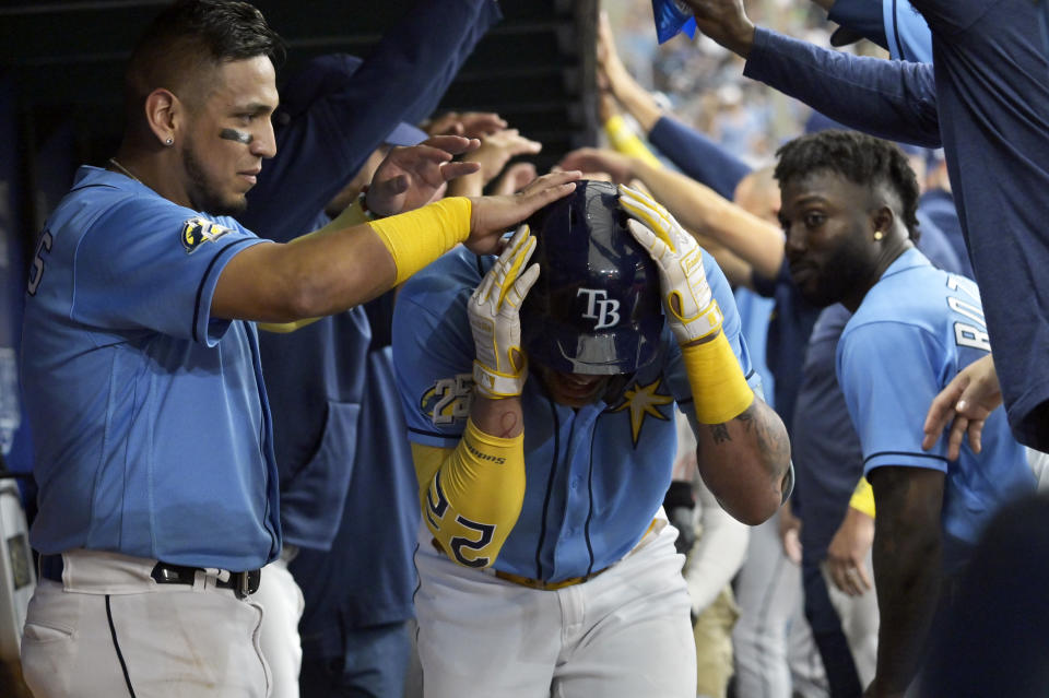 Tampa Bay Rays' Isaac Paredes, left, and Randy Arozarena, right, congratulate Jose Siri, center, in the dugout after Siri's solo home run off Kansas City Royals starter Daniel Lynch during the fourth inning of a baseball game Sunday, June 25, 2023, in St. Petersburg, Fla. (AP Photo/Steve Nesius)