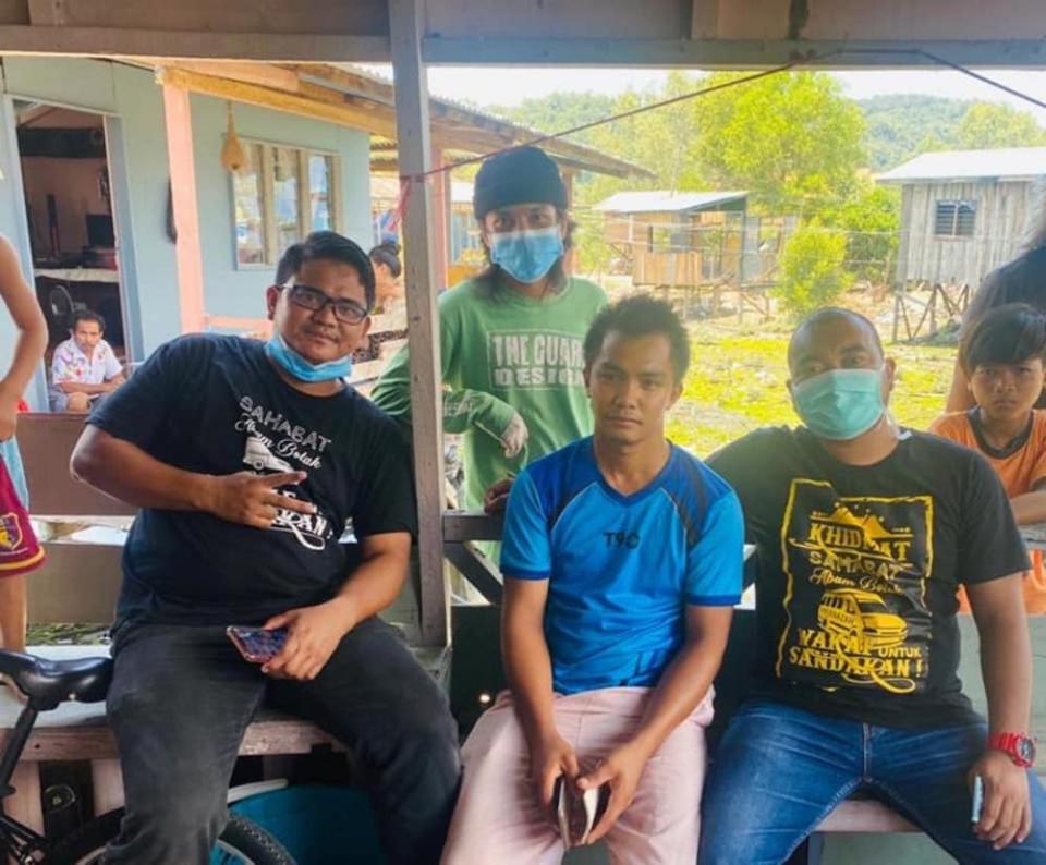 Yunizam (on the right) along with his distribution team with Fendi (middle) at his home. — Photo courtesy of Facebook/Abam Botak