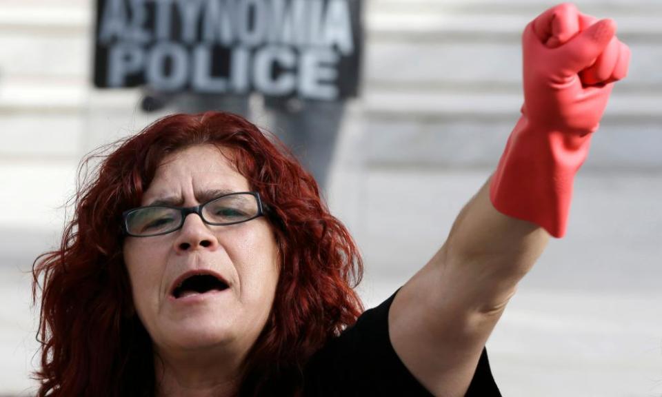 A cleaner puts her rubber gloves to work in a protest in Athens.