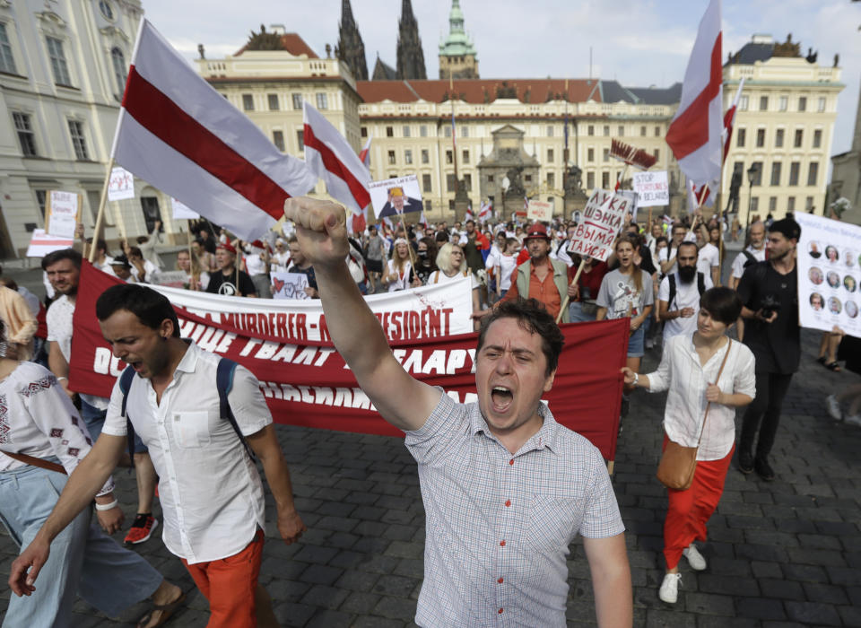 Demonstrators shout slogans as hundreds of people, among them many Belarusians, march in support of Belarusian demonstrators facing a brutal crackdown from the government of President Alexander Lukashenko near the Prague Castle in Prague, Czech Republic, Saturday, Aug. 15, 2020. (AP Photo/Petr David Josek)