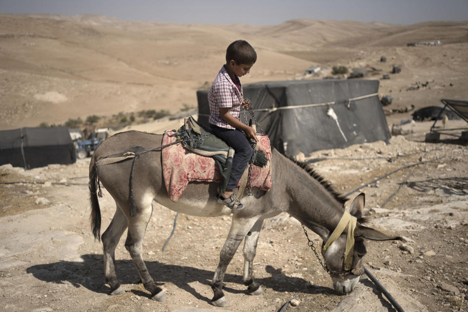 Ali, 5, sits on the donkey that carried him to a hospital when he was sick with a fever in Masafer Yatta, south Hebron hills, Monday, Sept. 4, 2023. This month the Israeli military confiscated Palestinian cars from his community, giving sick and injured residents no choice but to ride a donkey to the hospital — a bumpy two-hour trip that takes 30 minutes by car. Israel contends that Palestinians living there were never permanent residents and it has the right to declare the area a closed military zone. (AP Photo/Maya Alleruzzo)